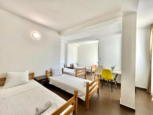 Un dormitorio con dos camas y una mesa y sillas. en Hotel Lobo Budva, en Budva