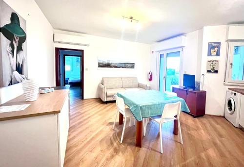 Una cocina y una sala de estar con mesa y sillas. en Wind surf love, en Marina Julia