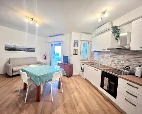 Una cocina y una sala de estar con una mesa y un sofá. en Wind surf love, en Marina Julia