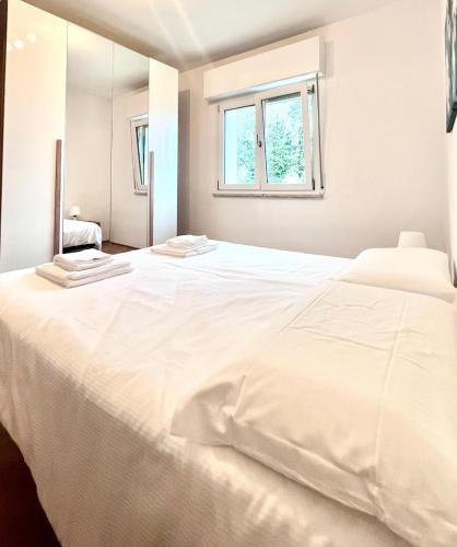 a large white bed in a room with a window at JuliaHome in Marina Julia