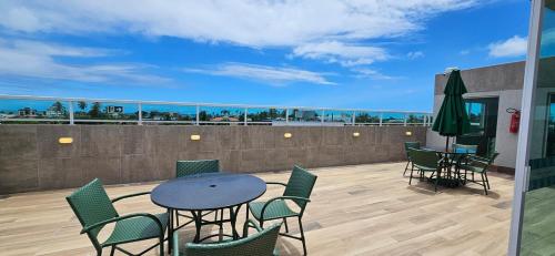 a patio with a table and chairs on a balcony at Na Praia Flats Centro AD 108 in Porto De Galinhas