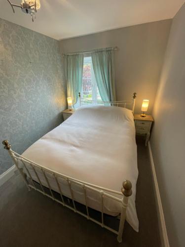 a bedroom with a white bed with a window at Chew Valley Retreat Suite in Bishop Sutton