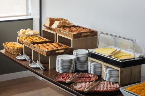 un buffet con platos y comida en una mesa en Palladium Business Hotel, en Montevideo