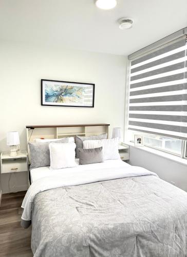 a bedroom with a large bed and a window at Cozy 1-Bedroom with Downtown City views in Edmonton