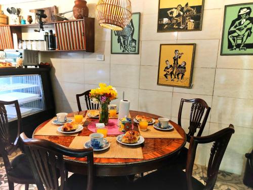 una mesa de comedor con comida y flores. en Flor de Lino Hotel Porteño, en Buenos Aires