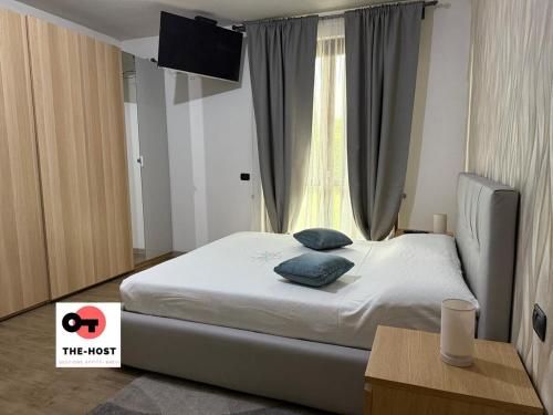 a bedroom with a bed with blue pillows and a window at Large apartment with garden and cinema room in Giussano