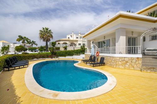 a swimming pool in front of a house at Villa Sitambo- Pool & Sea View in Albufeira