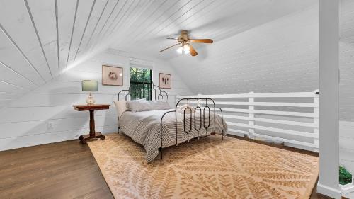 ein Schlafzimmer mit einem Bett und einem Deckenventilator in der Unterkunft Lakeside Cabin w Hot Tub Fireplace Near Dollywood Trails Smoky Shores Retreat by AvantStay in Little Cove