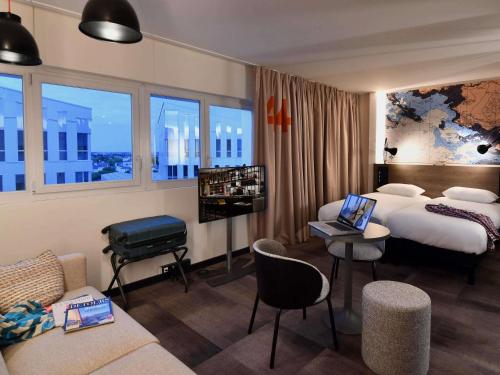サン・ナゼールにあるibis Styles Saint Nazaire Centre Gareのベッドとソファのあるホテルの部屋
