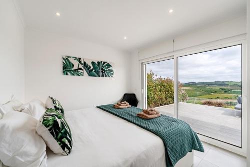 a bedroom with a bed and a large window at Villa Adão Lobo in Adão Lobo