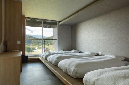 Ένα ή περισσότερα κρεβάτια σε δωμάτιο στο 全室から富士を望み 広い庭で憩う別荘