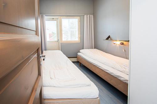 een kleine kamer met twee bedden en een raam bij Ski Center Alpine Houses A5 in Levi