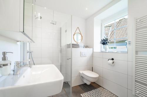 a white bathroom with a sink and a toilet at Wohlfühlen in Scharbeutz-Gleschendorf Komfort für 4 in Scharbeutz