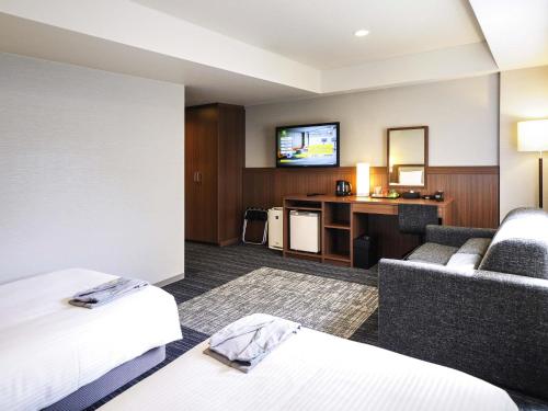 a hotel room with a bed and a tv at ibis Styles Kyoto Shijo in Kyoto