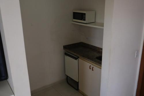 a small kitchen with a sink and a microwave at Maktub Hotel Itu in Itu