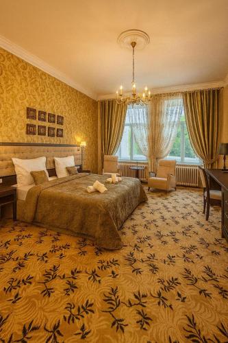 a bedroom with a large bed and a large window at Hotel Rudolf II Karlovy Vary in Karlovy Vary
