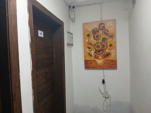 a painting of flowers on a wall next to a door at MV Grand Hotel in Apenkwa
