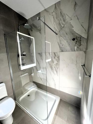 a bathroom with a glass shower and a toilet at Deluxe Penthouse Charming Location Rooftop Views in Marsaxlokk