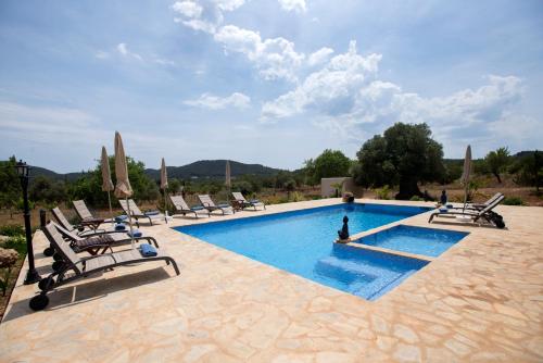 een zwembad met ligstoelen en een persoon in het water bij Villa Andreuet in Playa Aguas Bancas