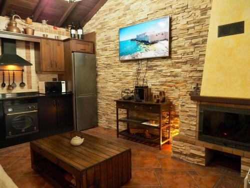 Una cocina con un televisor en una pared de ladrillos. en Casa Cruz De Tierno, en Vallehermoso