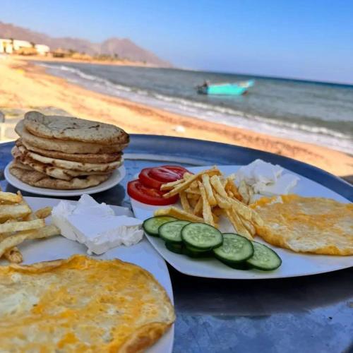 a blue plate with breakfast food on the beach at Gammal Boutique Camp in Nuweiba‘ el Muzeinah
