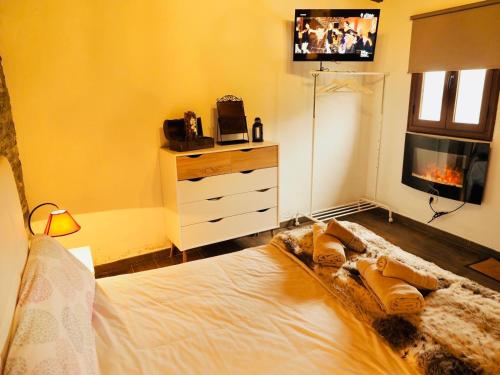1 dormitorio con 1 cama, TV y vestidor en Casa Cruz De Tierno, en Vallehermoso
