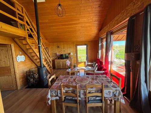 a dining room with a table and chairs in a cabin at Chalet des Gardettes, belle vue 1220m d'altitude in Montgreleix