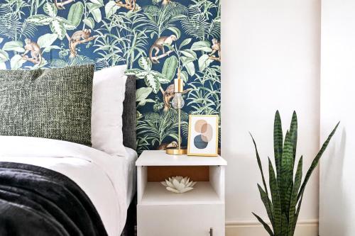 a bedroom with a bed and a plant at Modern Ealing Broadway Apt -2 mins To Tube & Well-Equipped in Ealing