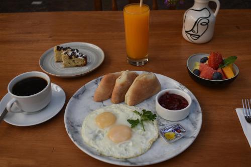 a table with a breakfast of eggs and bread and coffee at Nodo Cusco Garcilaso in Cusco
