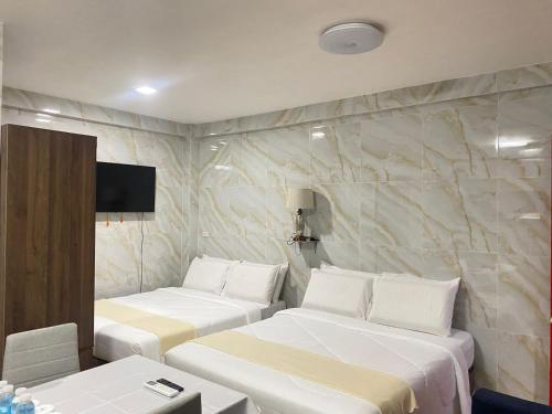 a room with two beds and a tv on a wall at MDM Hotel in Cordova