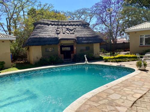 a house with a swimming pool in front of a house at Poolside Executive Suite near Airport - 2322 in Harare