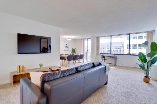 a living room with a couch and a dining room at A Few Steps From Airport - Stylish Apt in Addison Heights