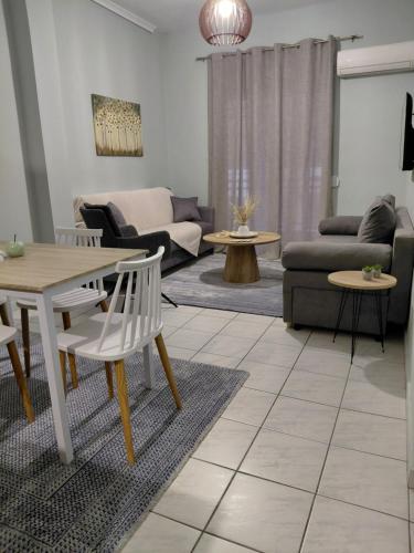 a living room with a table and chairs at Simply Like Home in Kavala