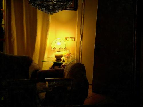 a living room with a lamp on a glass table at Il Bacio di Roma in Infernetto