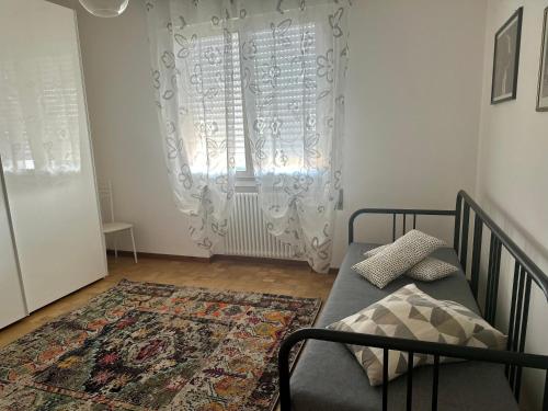 a bedroom with a bed and a window and a rug at La casa di Emilio in Ponte San Nicolo