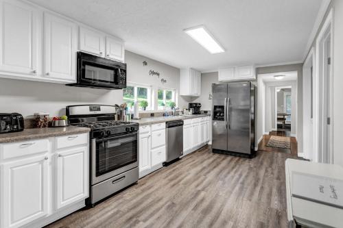 a kitchen with white cabinets and stainless steel appliances at Grill & Chill Retreat in Acworth