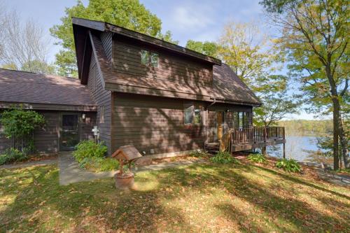 an old house with a porch and a deck at Rice Lake Cabin Retreat with Red Cedar Lake Access! in Rice Lake