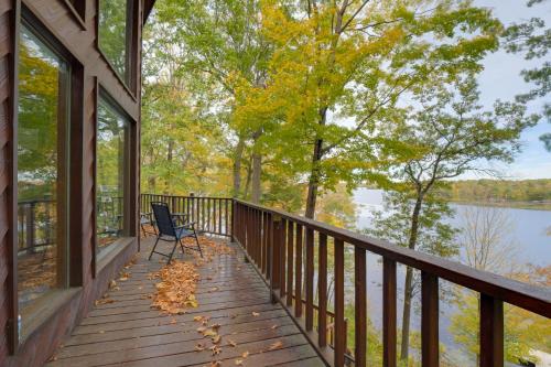 a porch with a chair and a view of a lake at Rice Lake Cabin Retreat with Red Cedar Lake Access! in Rice Lake