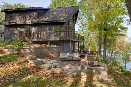 a house with a fire pit in front of it at Rice Lake Cabin Retreat with Red Cedar Lake Access! in Rice Lake