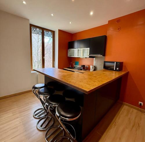 a kitchen with a counter with stools around it at Appartement proche des transports in Villeurbanne