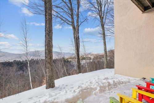 a snowy porch with a view of the mountains at Notchbrook 5 Apt. in Stowe