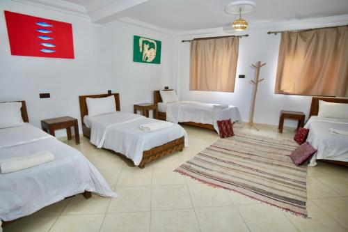 a room with two beds and a rug at Onda Surf in Taghazout