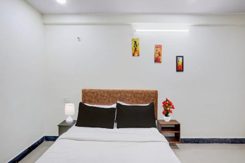 a bedroom with a large white bed with black pillows at Hotel O Khammam Railway Junction Formerly Raghavendra Inn in Khammam