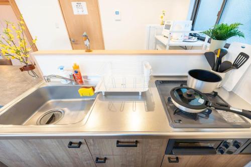 a kitchen with a sink and a stove top oven at Sakuraya 2 77m 2LDK 8 minutes to Hirokoji Station in Tokyo