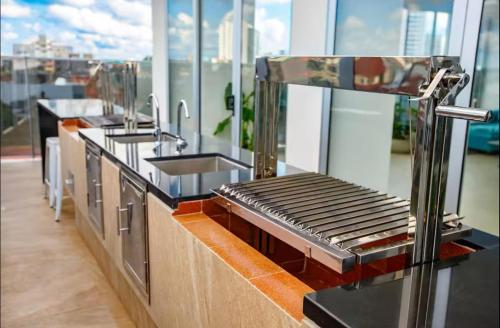 a kitchen with sinks and a counter top at APARTAMENTO COMODO EN EQUIPETROL TOTALMENTE AMOBLADO CON 2TVS CON NETFLIX, PISCINA TEMPERADA, GYM, CINE y PARQUEO cerca de Mall Ventura, Cines, restaurants y supermercados in Santa Cruz de la Sierra