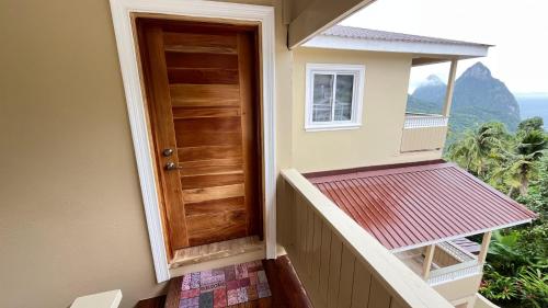 a door on the side of a house with a balcony at Tranquil Villas in Soufrière