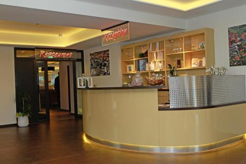 a restaurant with a counter in the middle of a lobby at Saterländer Hof in Ramsloh