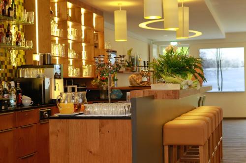 a bar with yellow stools in a restaurant at Saterländer Hof in Ramsloh