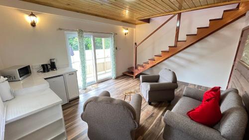 a living room with two couches and a staircase at Tranquil Villas in Soufrière