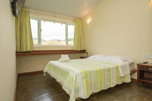 ein Schlafzimmer mit einem Bett und einem Fenster in der Unterkunft Pousada Verbicaro in Santa Maria Madalena